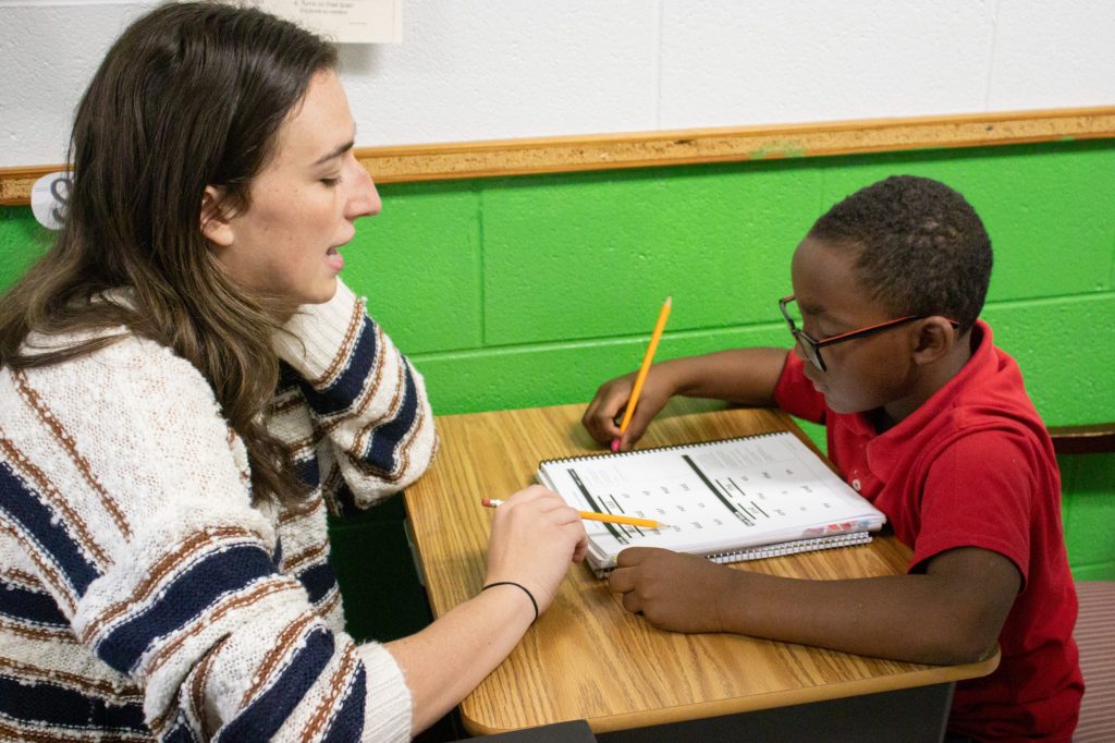 A teacher works with a student