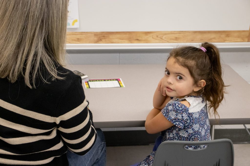 A teacher works with a student