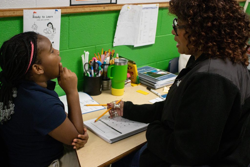 A teacher works with a student