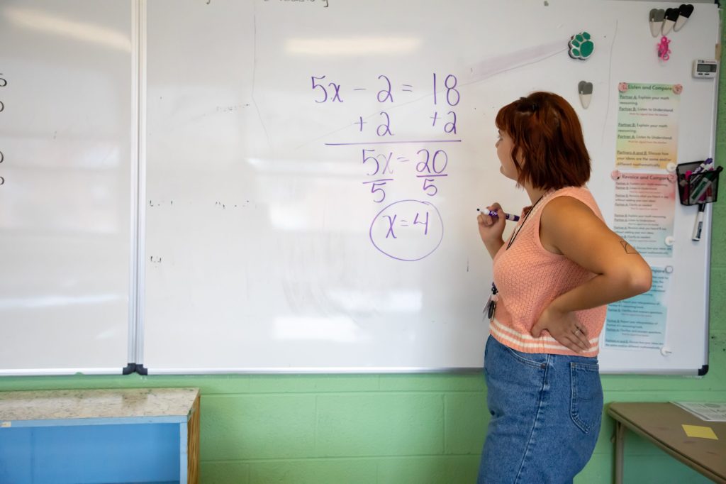 0D5A2068-2 teacher writing math on white board