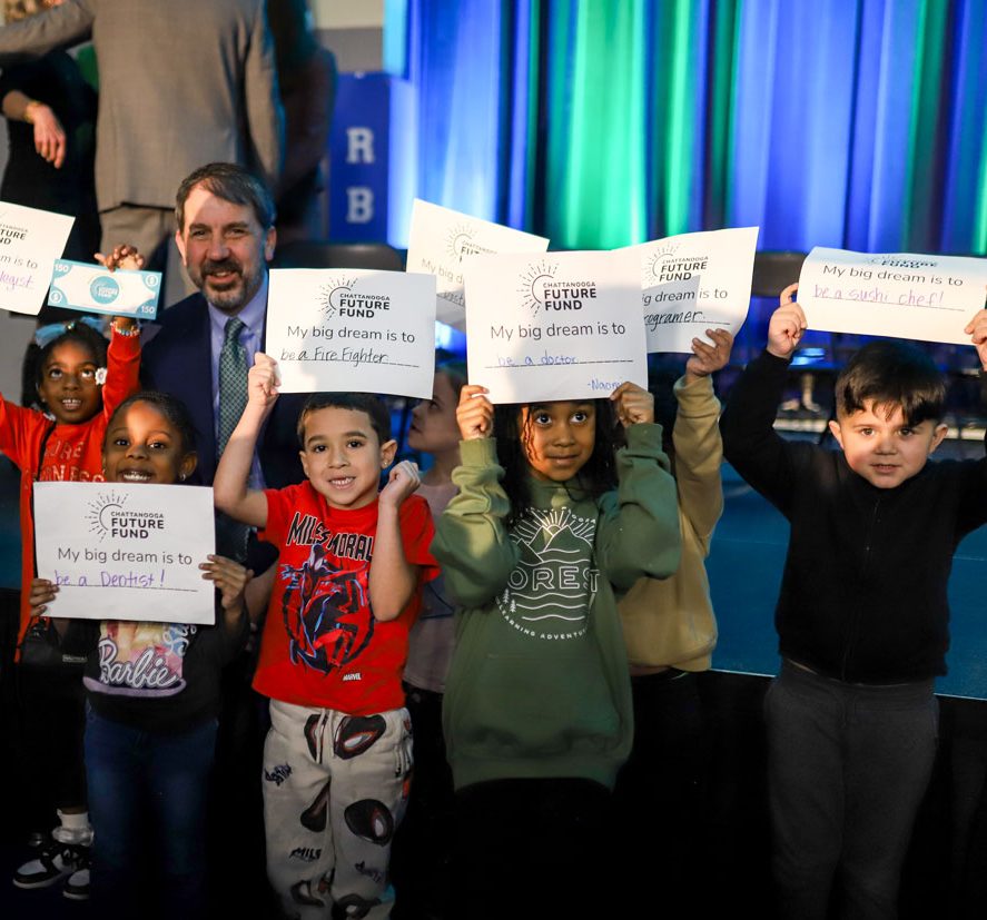 Dr Justin Robertson with kids holding future fund signs