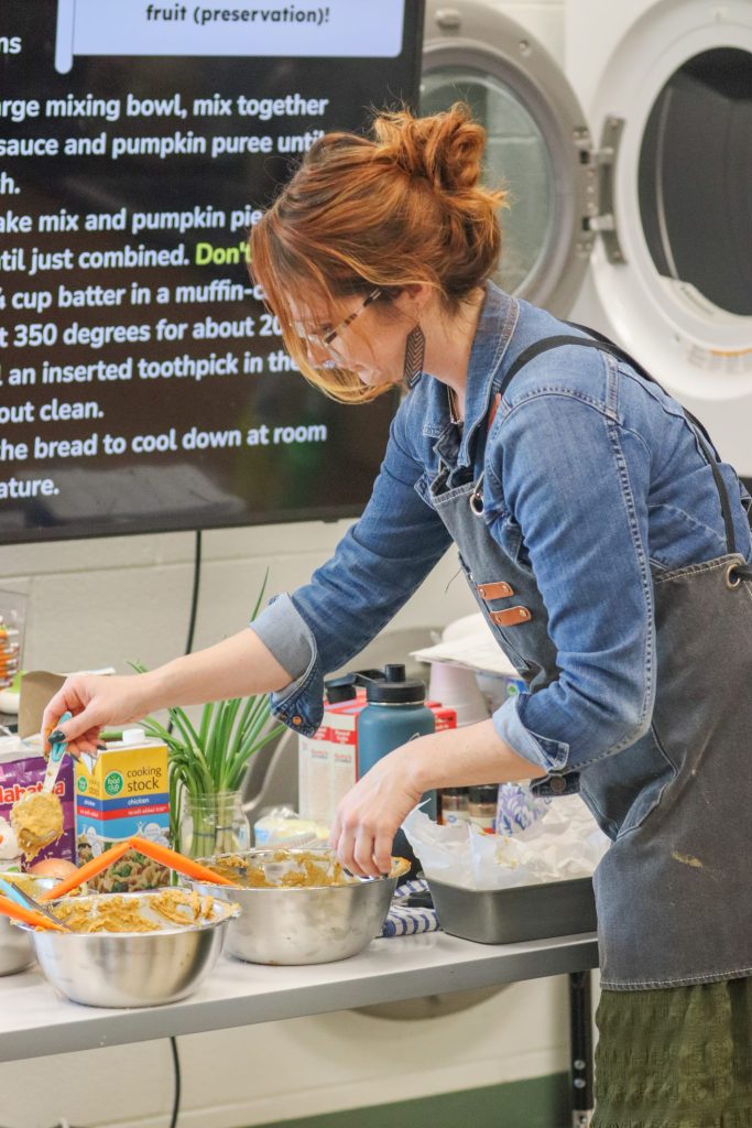 A teacher helps students bake