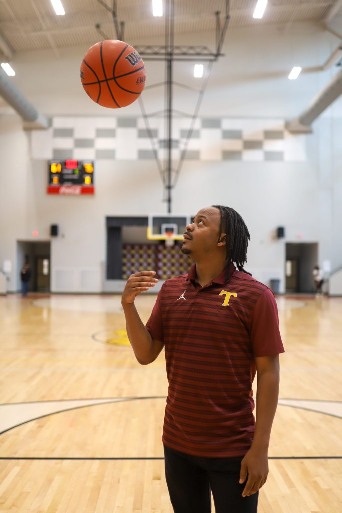 A coach tosses a basketball