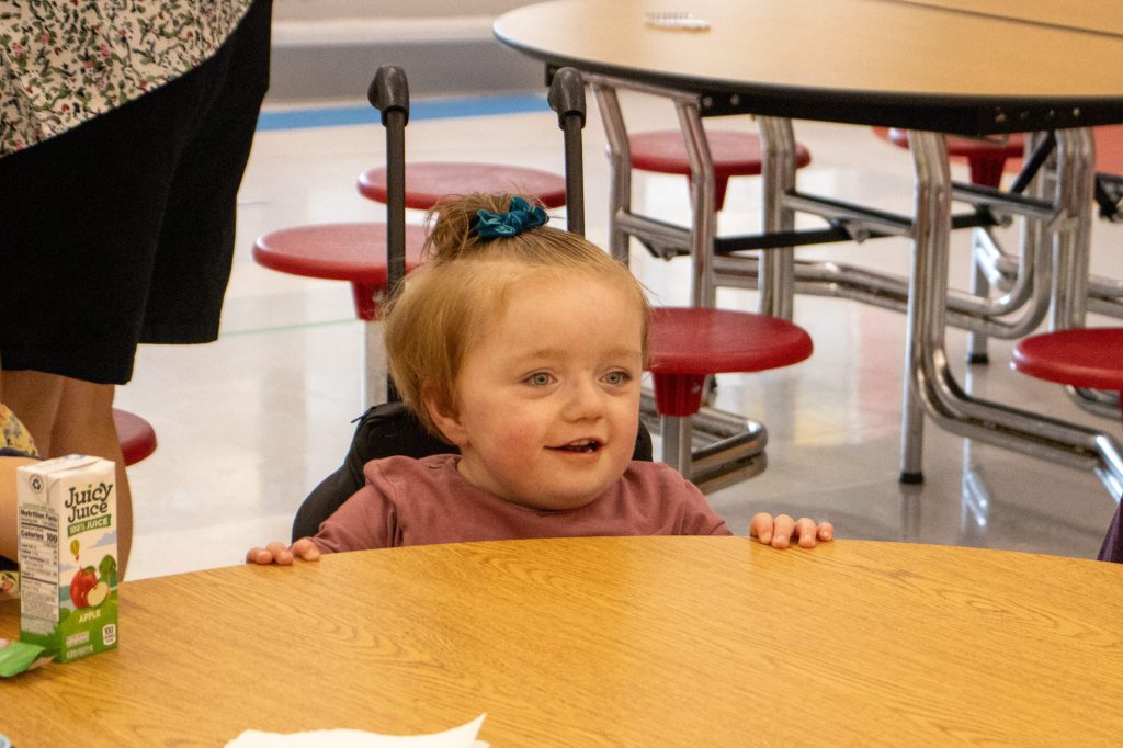 FirstDayEdited-77 child in wheelchair sitting at lunchroom table