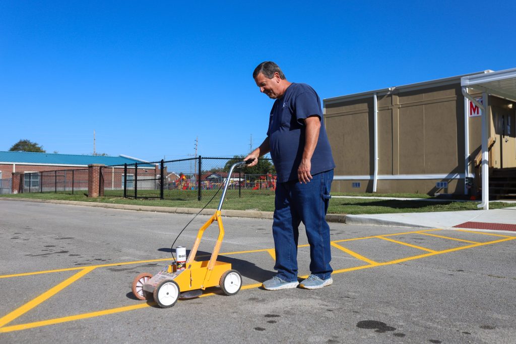 MAINT-1 A man spraypaints lines on the road