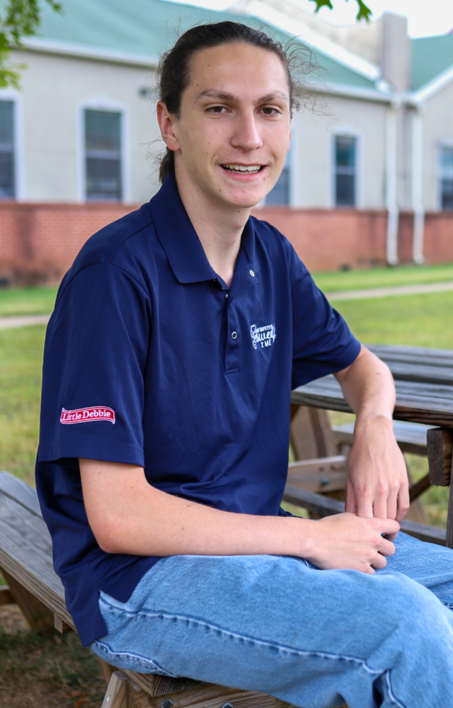 NEWSROOM COVER - Graduate Spotlight: Eldin Abdulahu man in little debbie shirt. Graduate