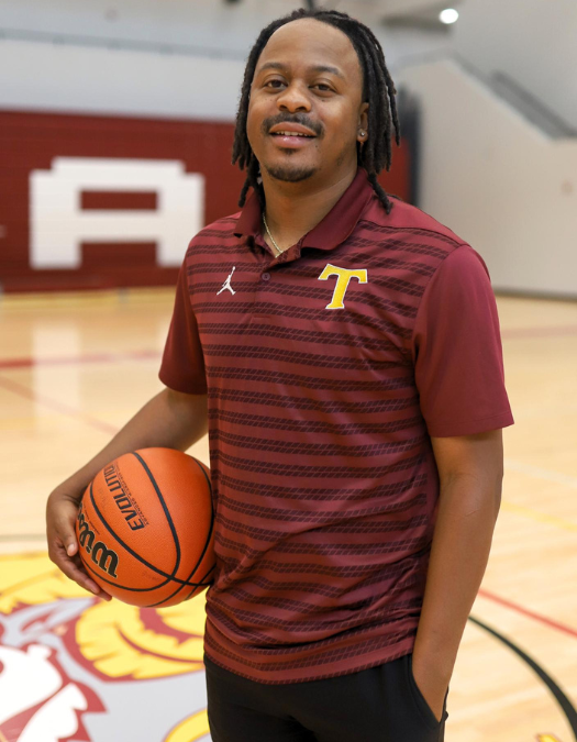 A coach poses for a photo