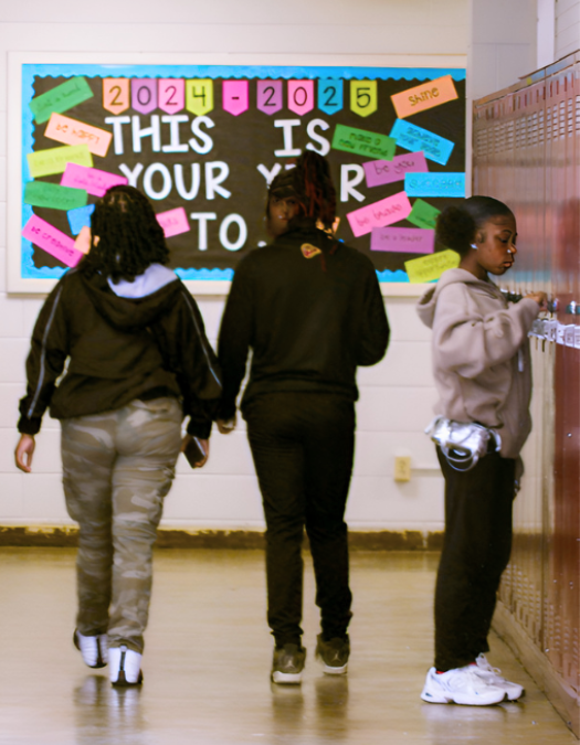 student using locker and students walking to class
