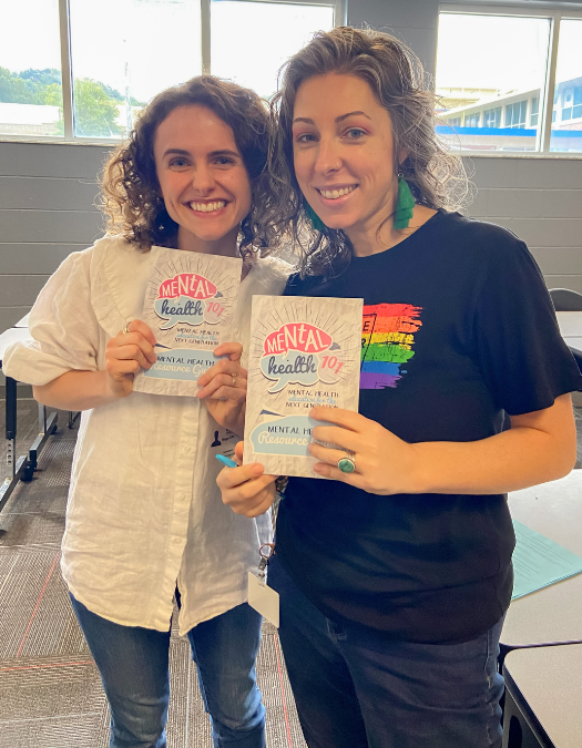 two teachers / counselors holding up mental health 101 pamphlets at red bank high
