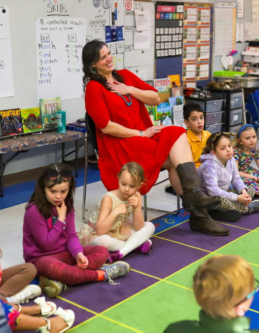 A teacher smiles in class