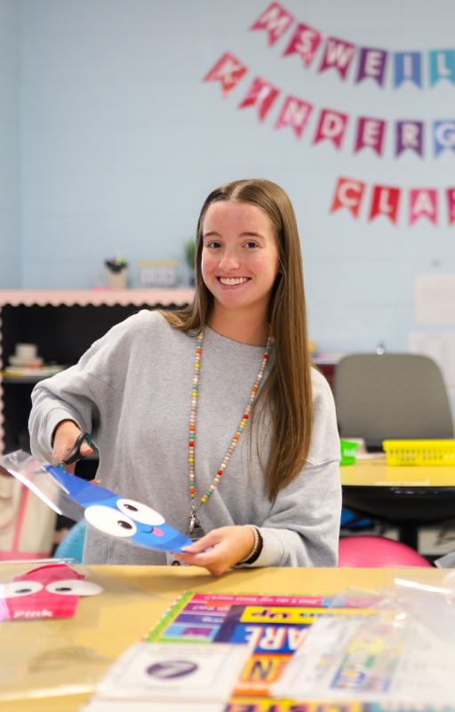 Weiler teacher smiling in classroom, cutting up art supplies