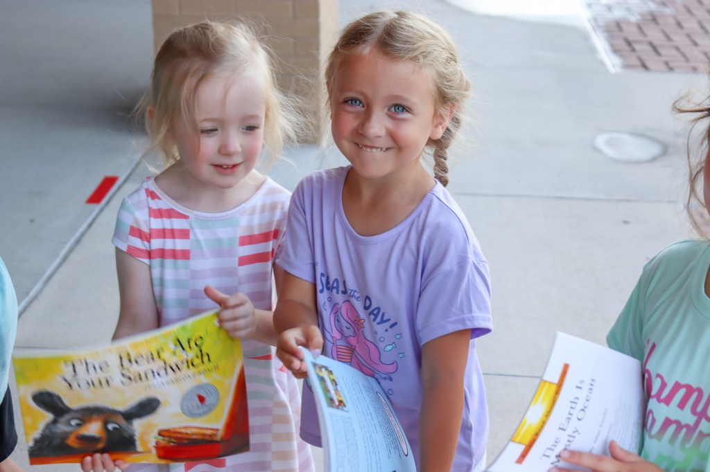 Book Bus Summer Reach MVE-10 smiling student holding book