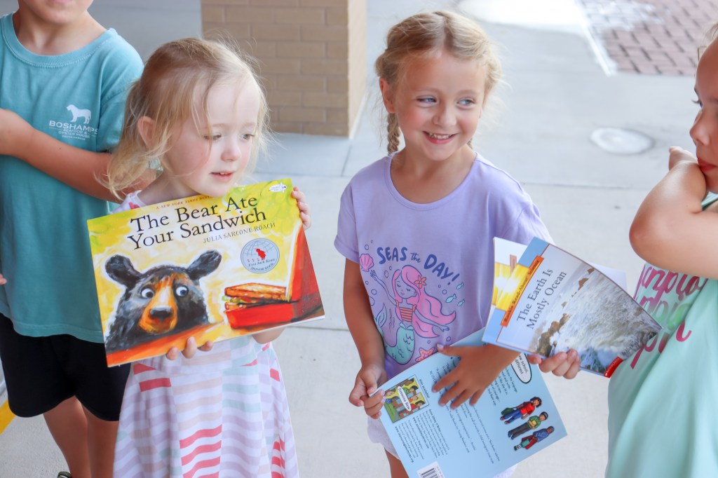 Book Bus Summer Reach MVE-11 smiling student holding book