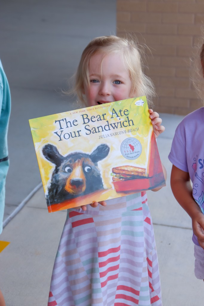 Book Bus Summer Reach MVE-12 smiling student holding book