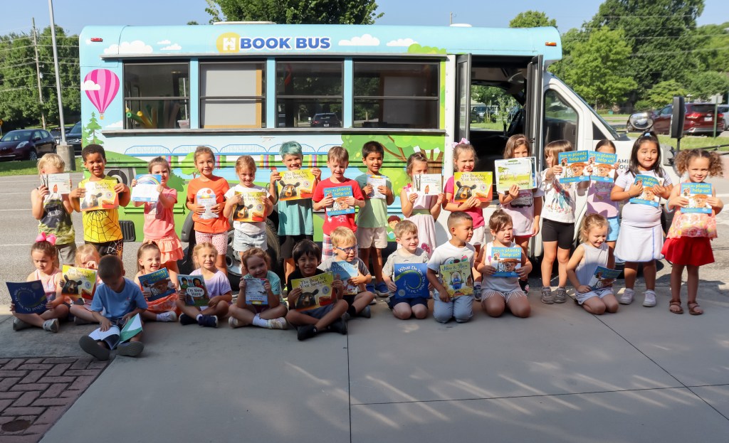 Book Bus Summer Reach MVE-13 smiling students holding books