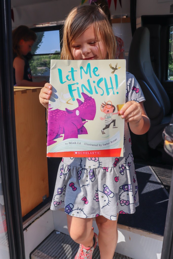 Book Bus Summer Reach MVE-17 smiling student holding book
