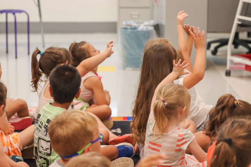 Book Bus Summer Reach MVE-2 students raising hands