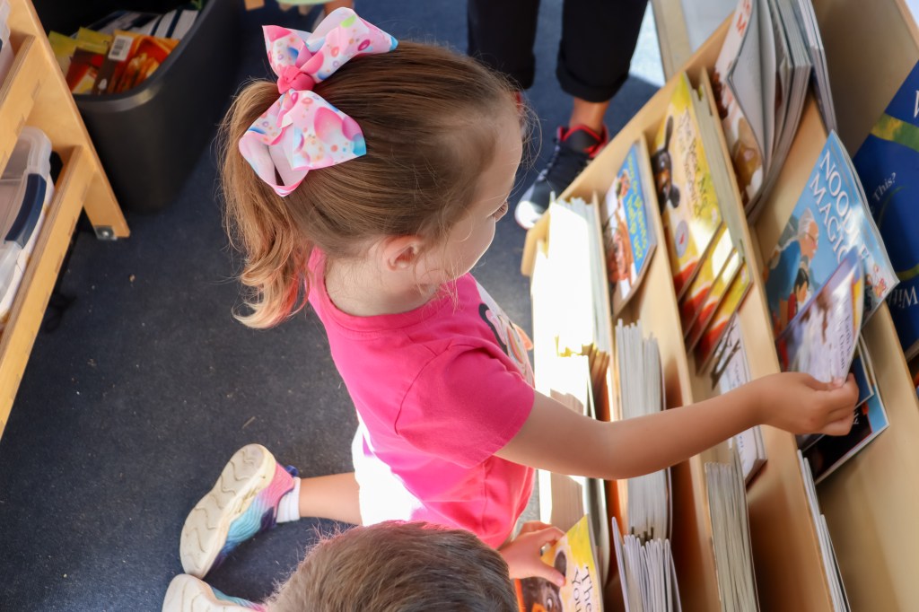Book Bus Summer Reach MVE-7 student looking at book