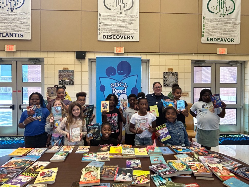 SDCL Read 20 2 students holding books for SDCL Read 20